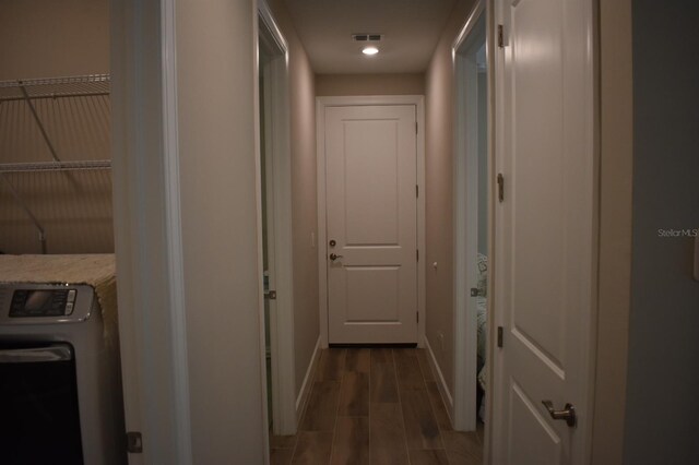 2735 Lavandula Ct, North Port, FL 34289 - hall featuring washer / dryer, baseboards, and wood finished floors