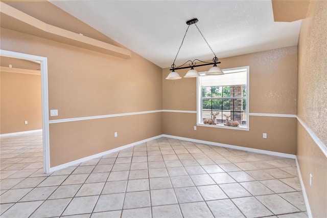 spare room featuring lofted ceiling and light tile patterned floors