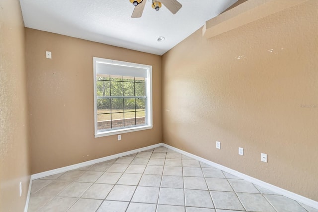 spare room with baseboards, ceiling fan, and light tile patterned flooring