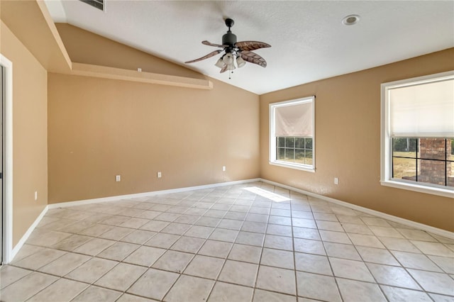 empty room with light tile patterned floors, a wealth of natural light, ceiling fan, and lofted ceiling