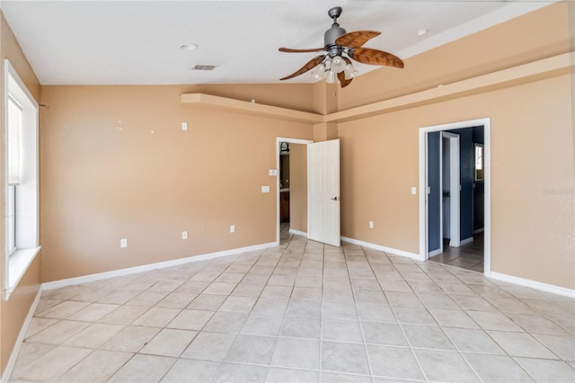 unfurnished room featuring ceiling fan, vaulted ceiling, light tile patterned floors, and visible vents