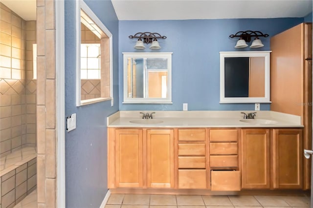 full bath with double vanity, a sink, baseboards, and tile patterned floors