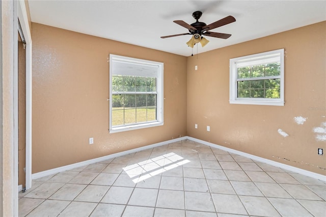 spare room with a ceiling fan, baseboards, and light tile patterned floors