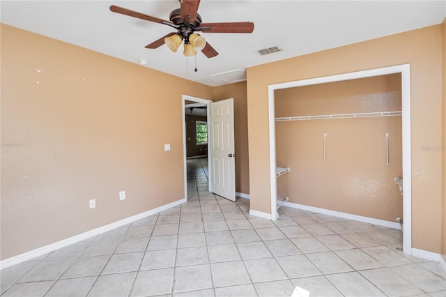 unfurnished bedroom with visible vents, a closet, baseboards, ceiling fan, and light tile patterned floors