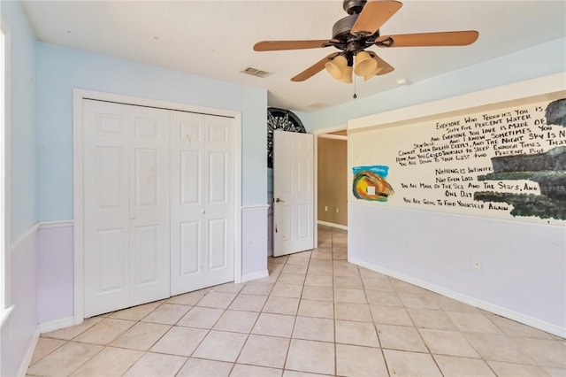 unfurnished bedroom featuring ceiling fan, visible vents, baseboards, a closet, and light tile patterned flooring