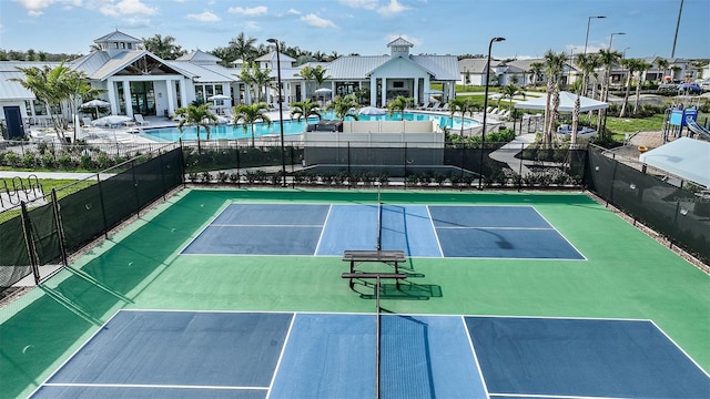 view of sport court featuring a community pool, fence, and a residential view