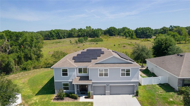 1940 Bell Creek Loop, Fruitland Park, FL 34731 - view of front facade with concrete driveway, an attached garage, solar panels, a shingled roof, and a gate
