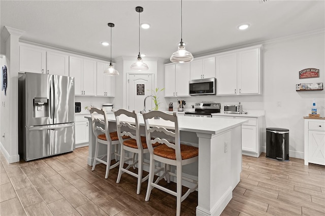 1940 Bell Creek Loop, Fruitland Park, FL 34731 - kitchen featuring stainless steel appliances, light countertops, light wood-style floors, a kitchen island with sink, and white cabinets