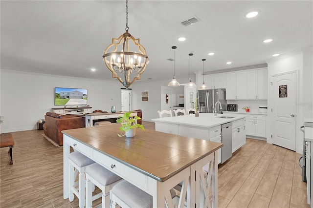 1940 Bell Creek Loop, Fruitland Park, FL 34731 - kitchen featuring appliances with stainless steel finishes, a sink, a center island with sink, crown molding, and recessed lighting