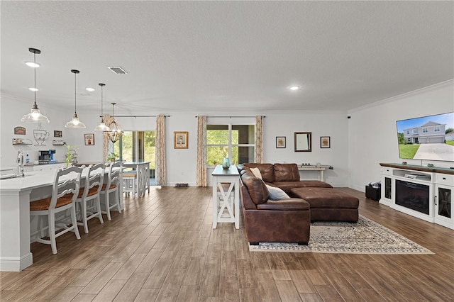 1940 Bell Creek Loop, Fruitland Park, FL 34731 - living room featuring wood finished floors, ornamental molding, recessed lighting, baseboards, and a chandelier