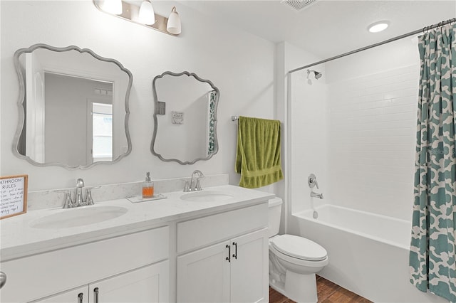 1940 Bell Creek Loop, Fruitland Park, FL 34731 - bathroom with wood finished floors, shower / tub combo with curtain, double vanity, and toilet