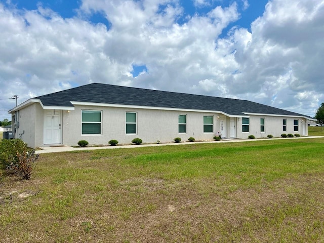 ranch-style house with stucco siding and a front lawn