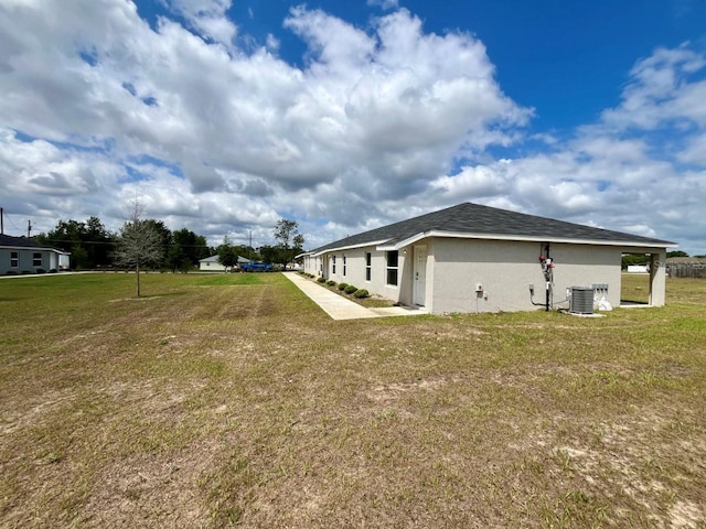 view of side of property with central air condition unit, a lawn, a patio area, and stucco siding
