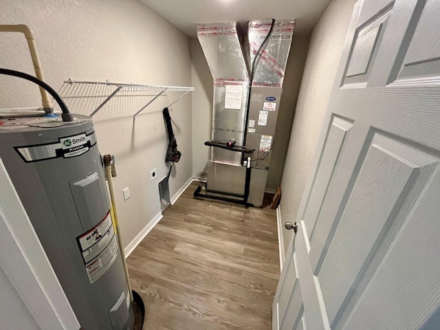 utility room with heating unit and water heater