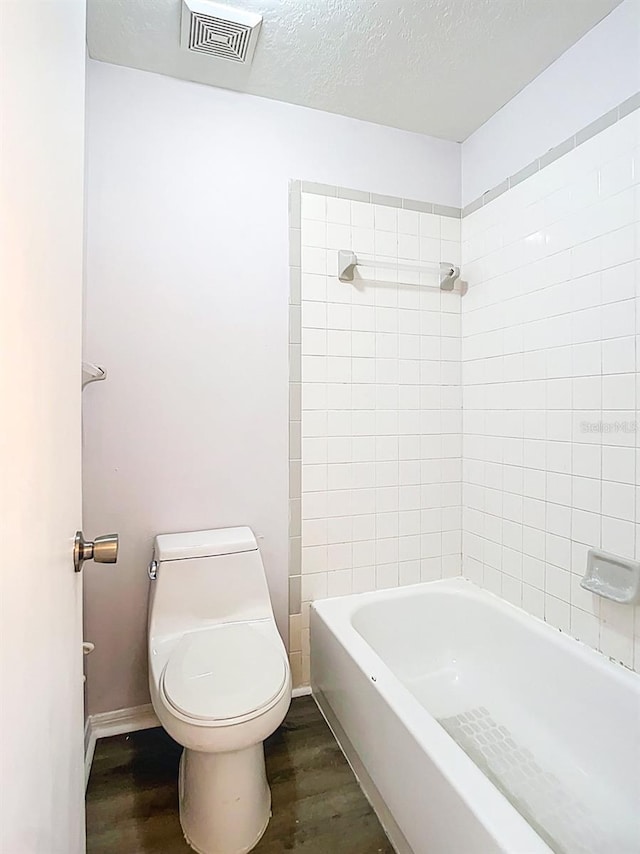 full bath with toilet, visible vents, wood finished floors, and baseboards