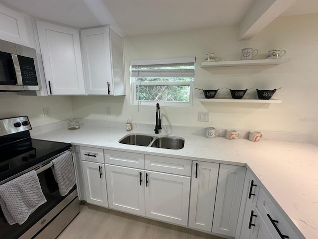 2217 Azalea Ct, Lakeland, FL 33815 - kitchen featuring stainless steel appliances, a sink, white cabinetry, light stone countertops, and light wood-type flooring