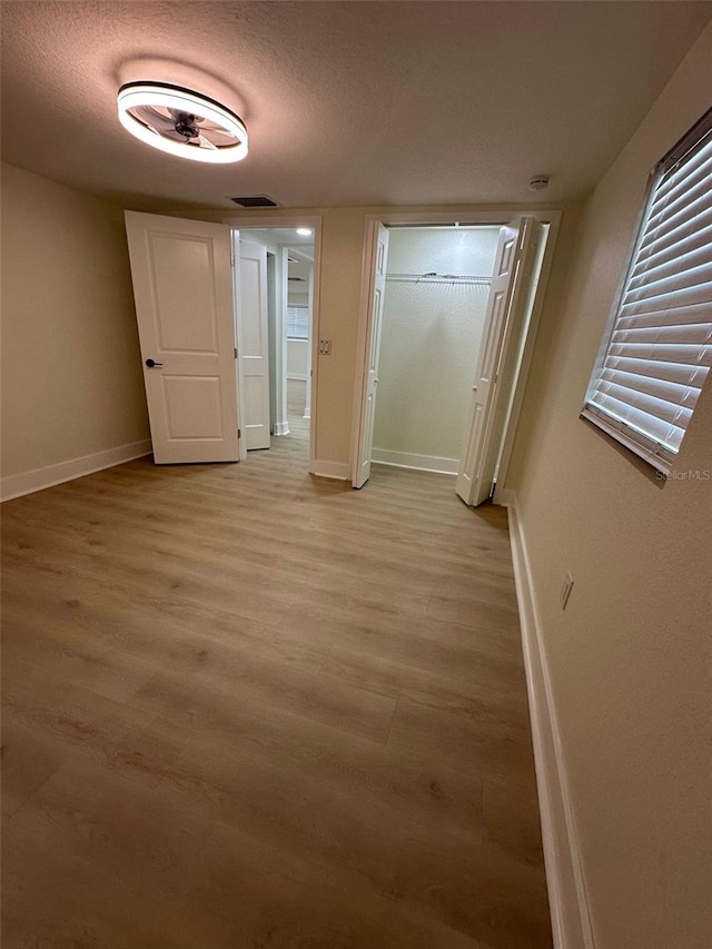 2217 Azalea Ct, Lakeland, FL 33815 - unfurnished bedroom featuring baseboards, light wood-style flooring, a textured ceiling, and a closet