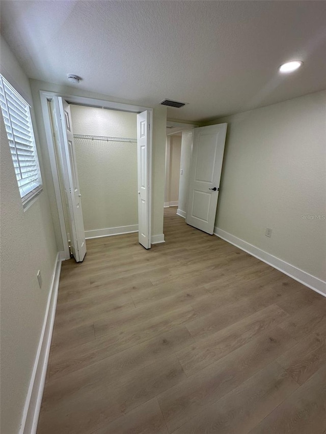 2217 Azalea Ct, Lakeland, FL 33815 - unfurnished bedroom featuring baseboards, light wood-style flooring, a closet, and a textured ceiling
