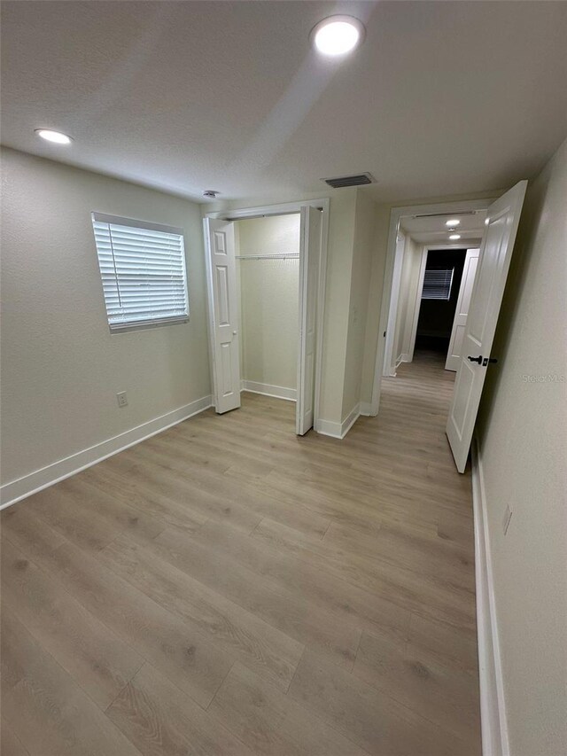 2217 Azalea Ct, Lakeland, FL 33815 - unfurnished bedroom featuring light wood-style flooring, baseboards, and a closet
