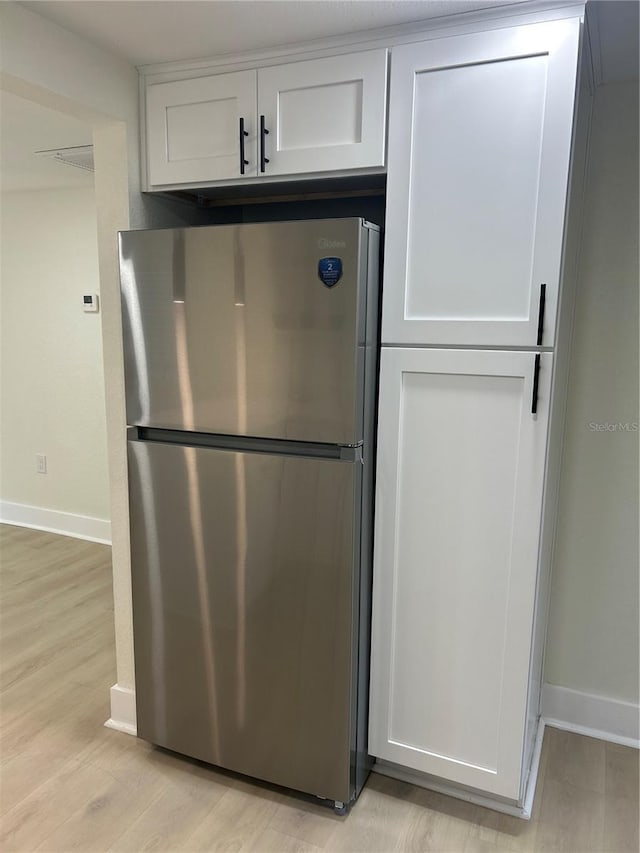 2217 Azalea Ct, Lakeland, FL 33815 - kitchen featuring freestanding refrigerator, light wood-style floors, baseboards, and white cabinets