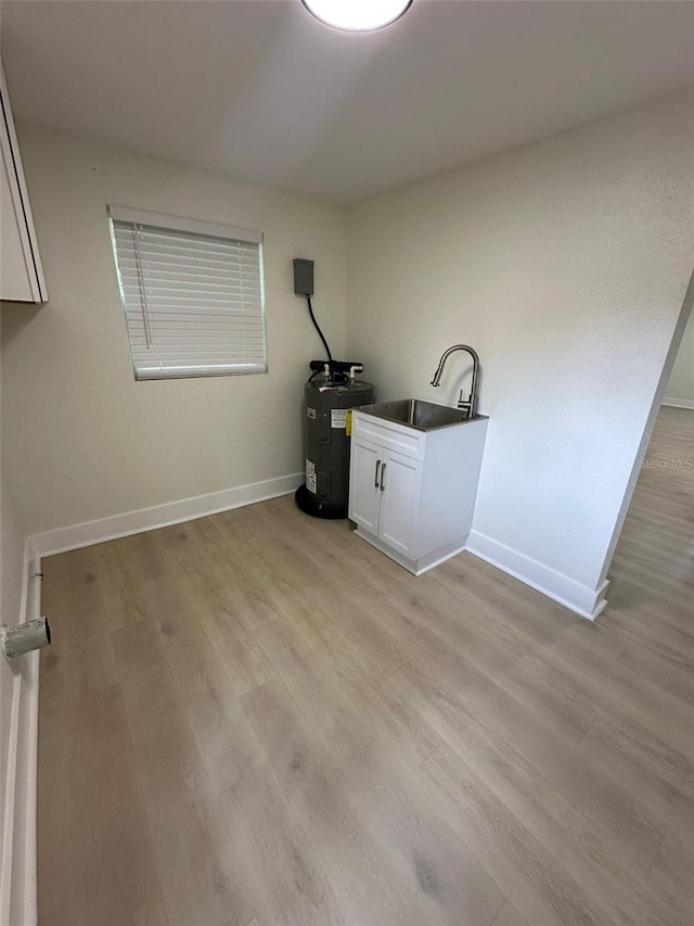 2217 Azalea Ct, Lakeland, FL 33815 - laundry area with electric water heater, baseboards, light wood-type flooring, and a sink