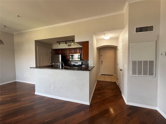 7320 Westpointe Blvd Unit 531, Orlando, FL 32835 - kitchen with appliances with stainless steel finishes, dark wood finished floors, decorative backsplash, ornamental molding, and baseboards