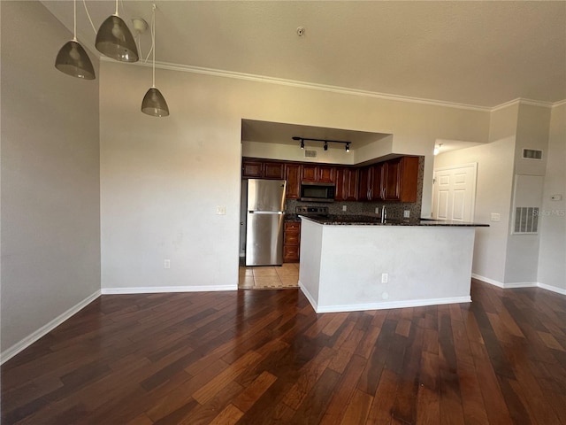 7320 Westpointe Blvd Unit 531, Orlando, FL 32835 - kitchen featuring appliances with stainless steel finishes, dark countertops, tasteful backsplash, hardwood / wood-style flooring, and ornamental molding