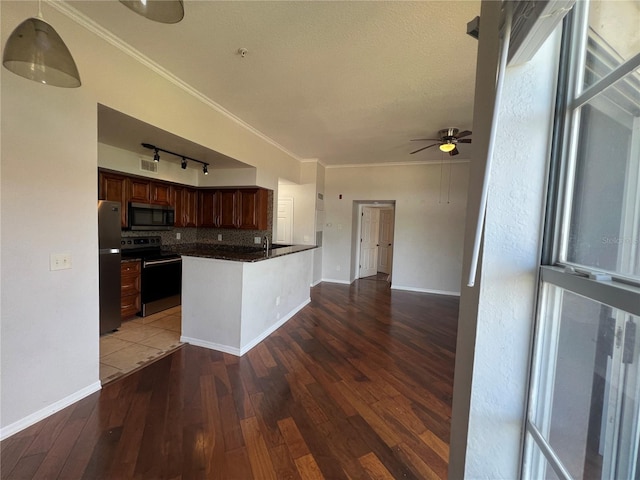 7320 Westpointe Blvd Unit 531, Orlando, FL 32835 - kitchen with appliances with stainless steel finishes, tasteful backsplash, ceiling fan, wood finished floors, and ornamental molding