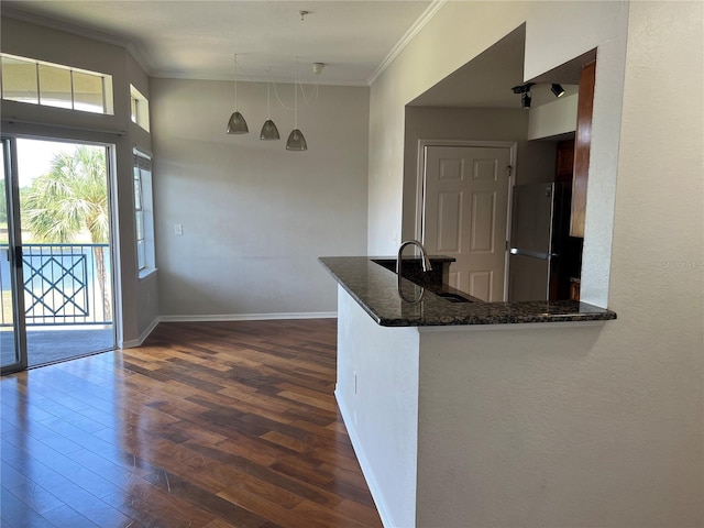 7320 Westpointe Blvd Unit 531, Orlando, FL 32835 - kitchen featuring freestanding refrigerator, a sink, ornamental molding, dark wood finished floors, and dark stone countertops