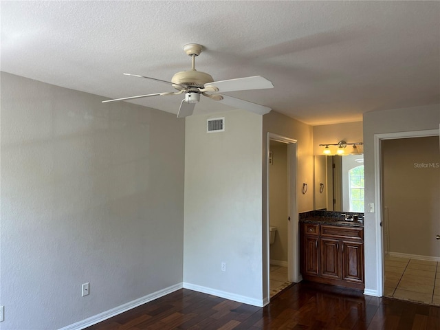 7320 Westpointe Blvd Unit 531, Orlando, FL 32835 - unfurnished bedroom with dark wood-type flooring, baseboards, ceiling fan, a textured ceiling, and a sink