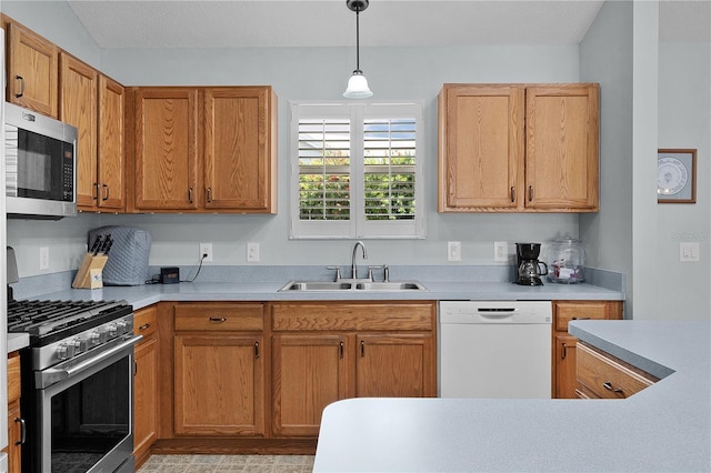 1305 Guerra Ave, The Villages, FL 32159 - kitchen featuring stainless steel appliances, a sink, hanging light fixtures, light countertops, and brown cabinets