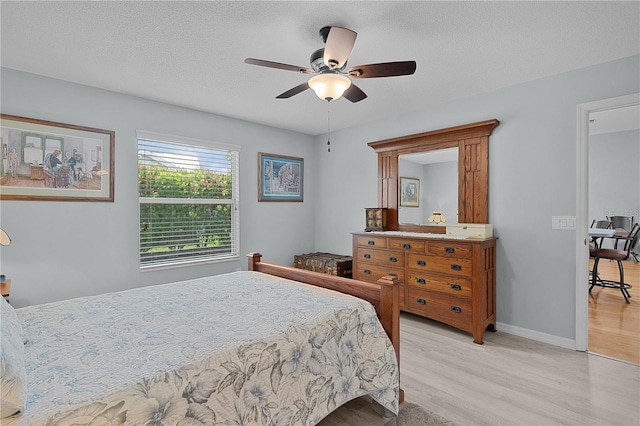 1305 Guerra Ave, The Villages, FL 32159 - bedroom featuring light wood-style flooring, baseboards, ceiling fan, and a textured ceiling