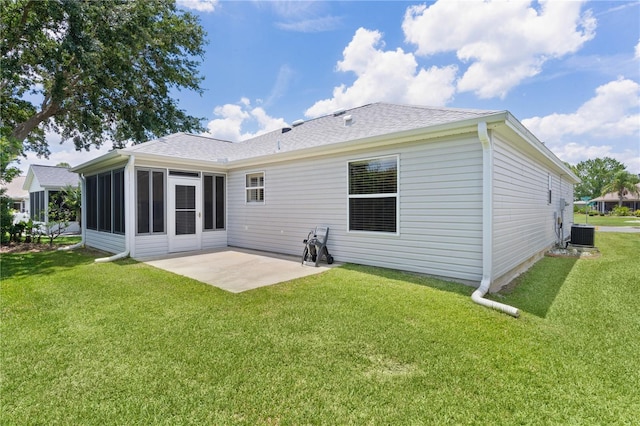 1305 Guerra Ave, The Villages, FL 32159 - rear view of house featuring a patio area, a lawn, cooling unit, roof with shingles, and a sunroom