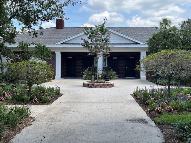 1305 Guerra Ave, The Villages, FL 32159 - view of front of home featuring a chimney, a shingled roof, and brick siding