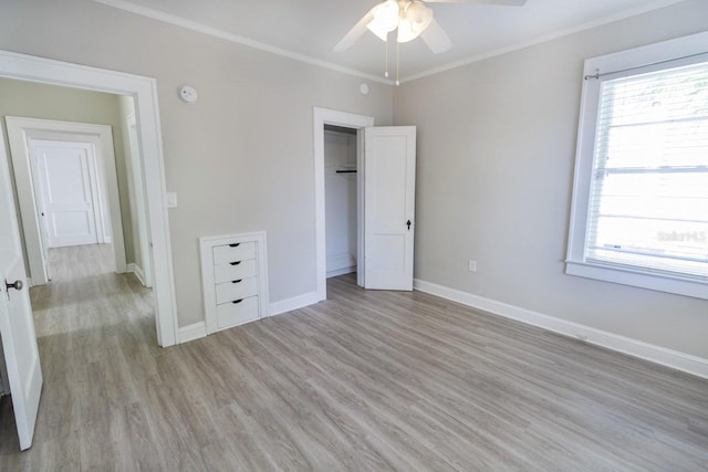 unfurnished bedroom with light wood finished floors, crown molding, baseboards, and ceiling fan