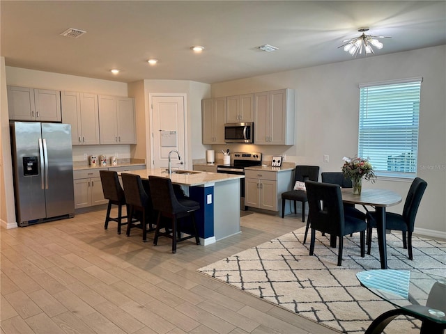43819 Cattleman Dr, Punta Gorda, FL 33982 - kitchen with appliances with stainless steel finishes, a sink, a breakfast bar, an island with sink, and recessed lighting