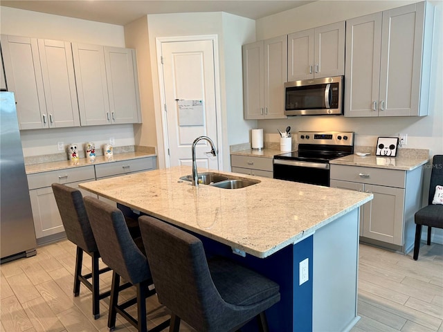 43819 Cattleman Dr, Punta Gorda, FL 33982 - kitchen with appliances with stainless steel finishes, a sink, gray cabinetry, light stone counters, and light wood-style flooring