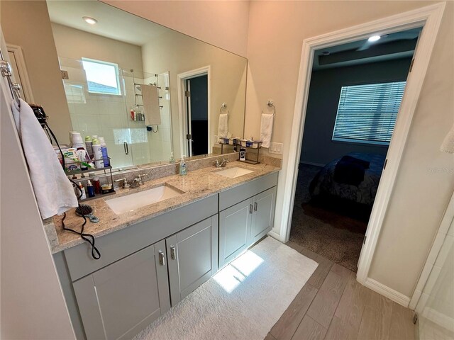 43819 Cattleman Dr, Punta Gorda, FL 33982 - full bathroom with a shower stall, wood finished floors, double vanity, and baseboards