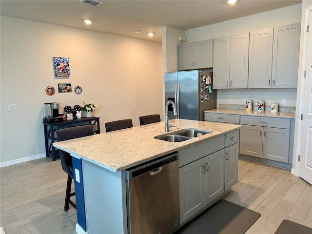 43819 Cattleman Dr, Punta Gorda, FL 33982 - kitchen featuring appliances with stainless steel finishes, a sink, gray cabinets, a breakfast bar area, and recessed lighting