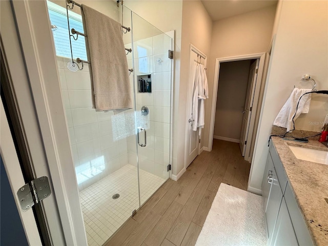 43819 Cattleman Dr, Punta Gorda, FL 33982 - bathroom featuring wood finished floors, a stall shower, baseboards, and vanity