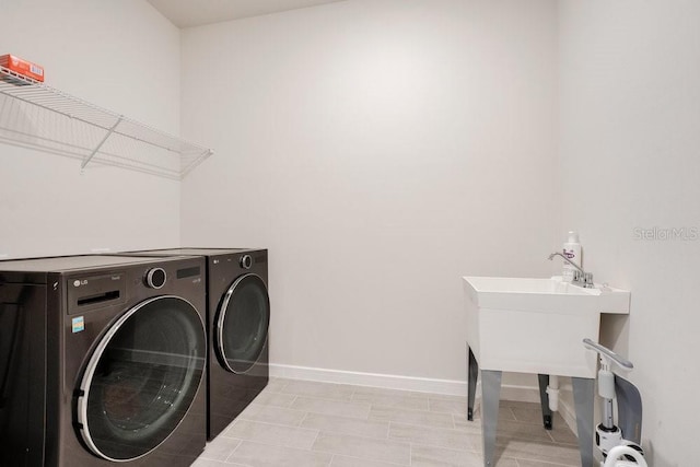 washroom featuring washing machine and dryer and baseboards