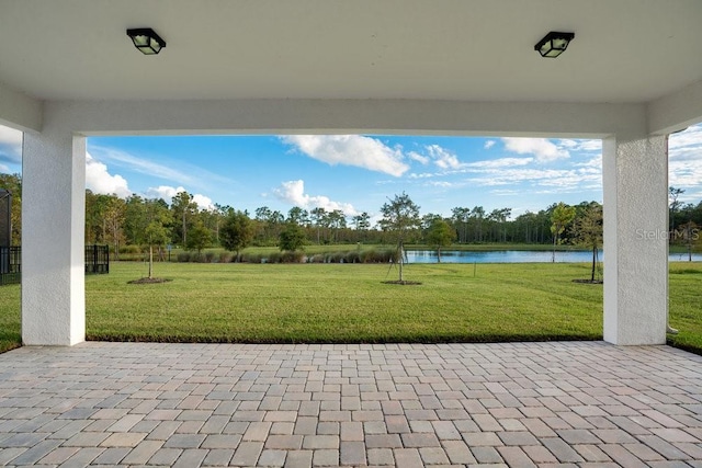 view of patio with a water view and view of scattered trees