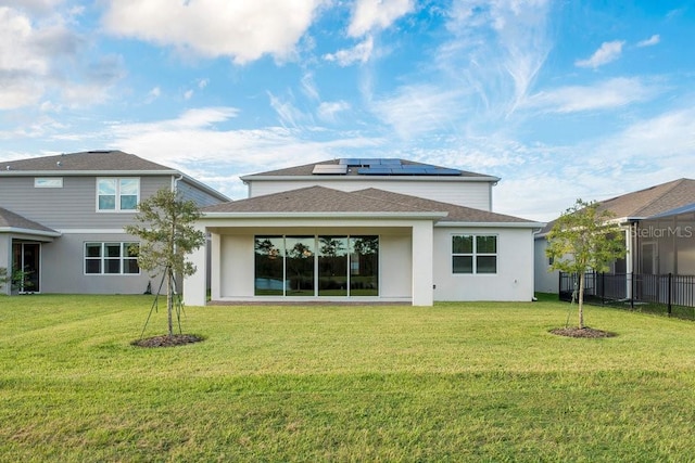 rear view of property with solar panels, stucco siding, and a shingled roof