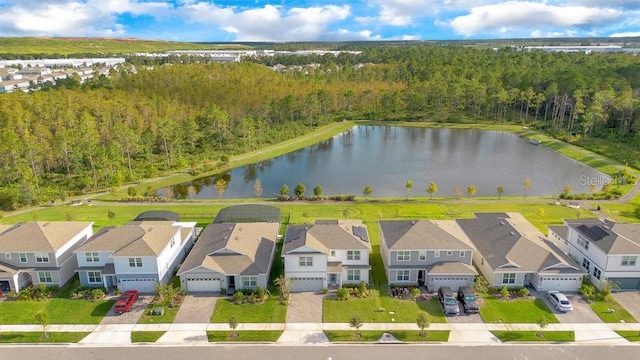 aerial view of residential area with a nearby body of water and a heavily wooded area