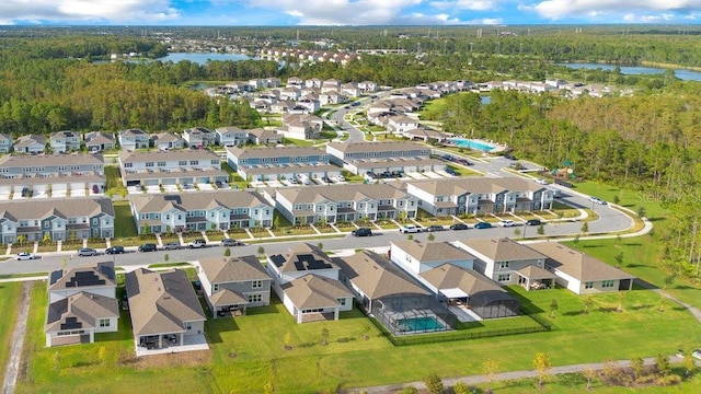 aerial perspective of suburban area featuring a large body of water and a heavily wooded area