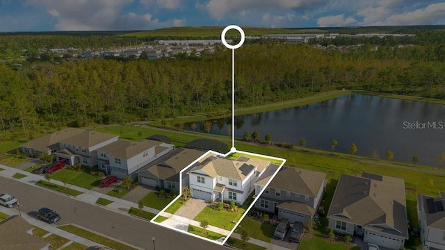 aerial perspective of suburban area with a forest, a nearby body of water, and property boundaries highlighted
