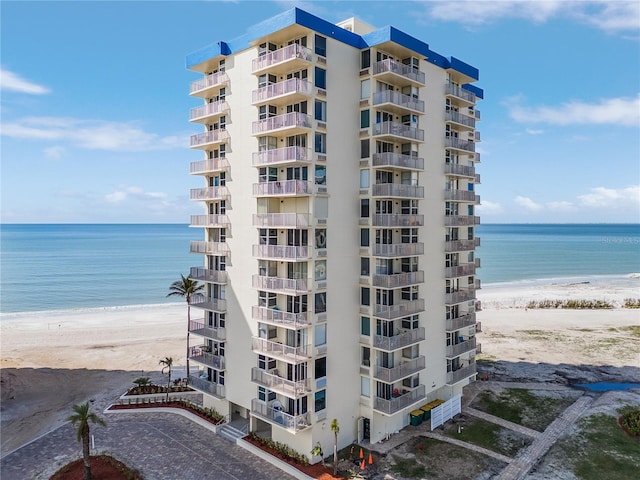 view of apartment building / complex featuring view of water and beach