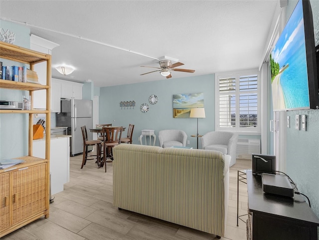 living area with ceiling fan and light wood-style floors