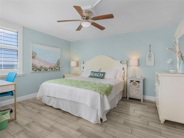 bedroom with light wood-style flooring, baseboards, and ceiling fan