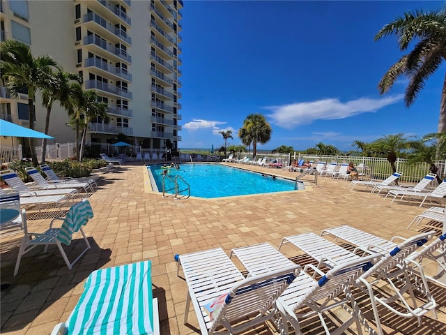 community pool featuring fence and a patio area